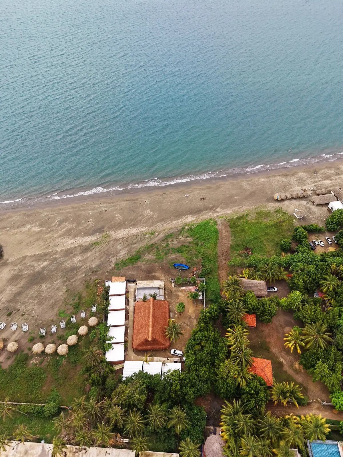 Vista aérea de Mokano Beach Hotel: el hotel con su palapa y cabañas a pocos pasos de la playa y el mar de Palmarito